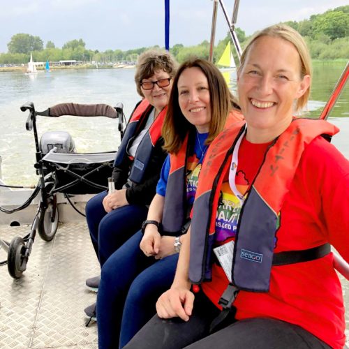 Three people smiling on a sailing boat at a Get Active Get Together event