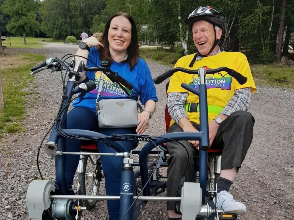 Coalition member and a Coalition staff member smiling on a tandem bike