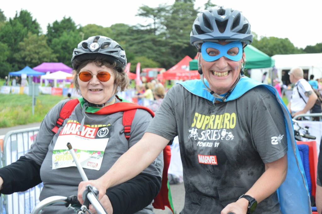 Coalition member Jane and staff member Katy smiling on a side by side tandem bike