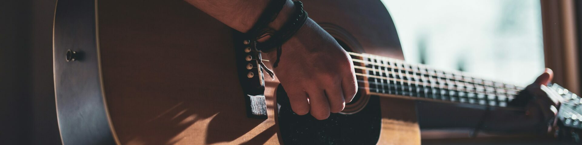 Close up photo of a person playing a guitar