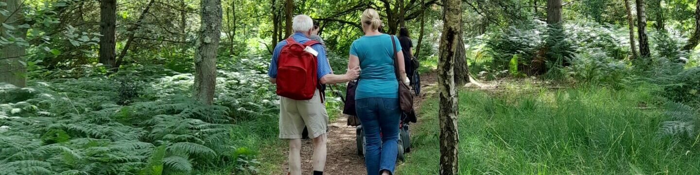 Katy guiding Coalition member Jonathan, on a Get More Active walk and wheel through a forest.