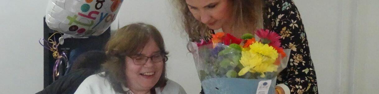 Sylwia giving Angie cards and flowers at the staff lunch