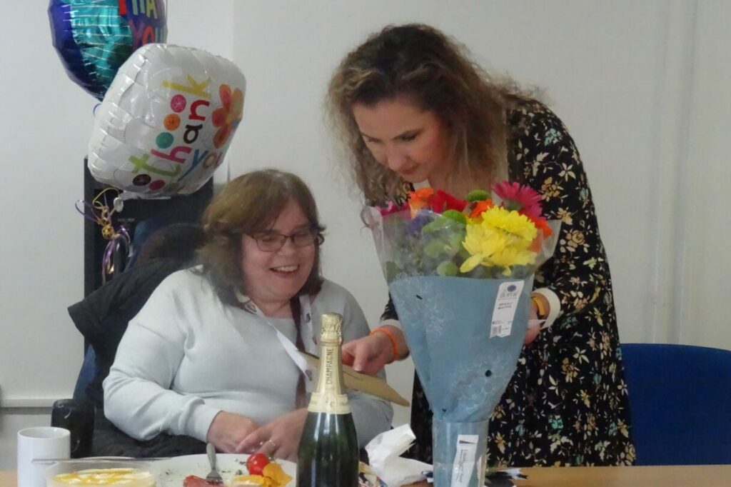 Sylwia giving Angie cards and flowers at the staff lunch