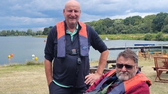 Coalition member and an Active Buddy volunteer by a lake at a Get More Active sailing event. 