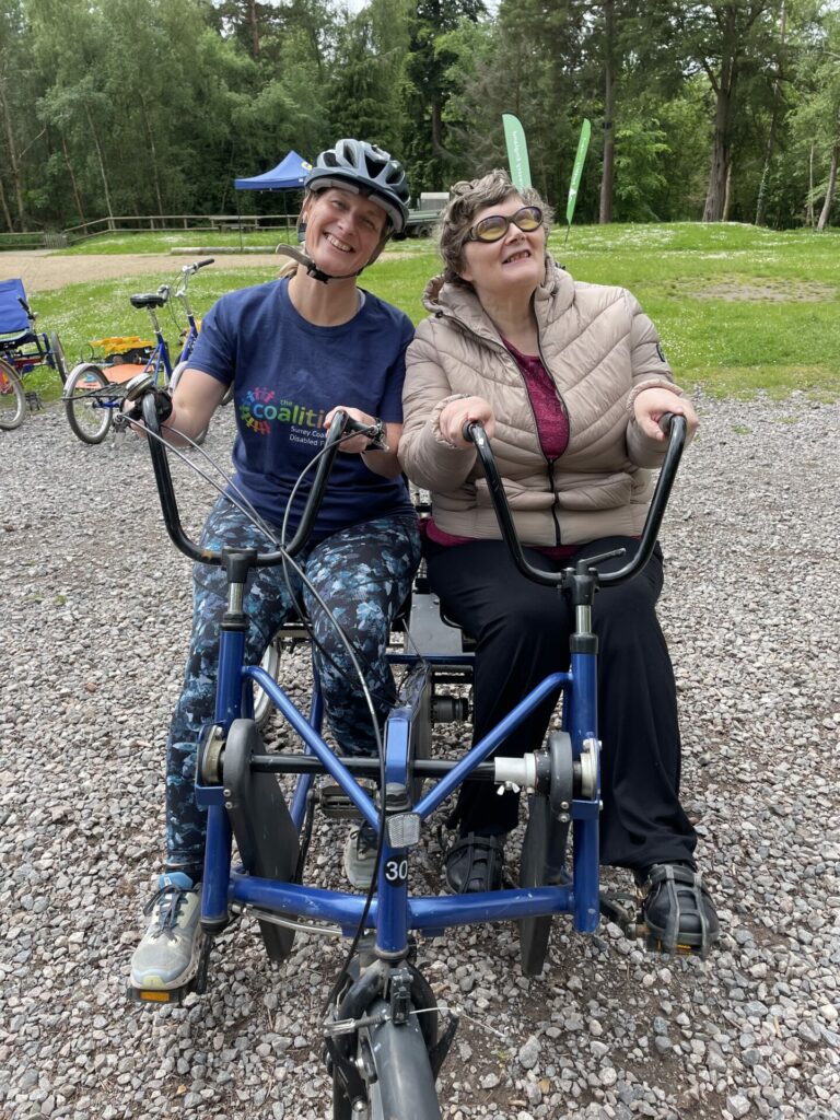 Coalition member Jane with Coalition staff member Katy on a side by side tandem bike. 