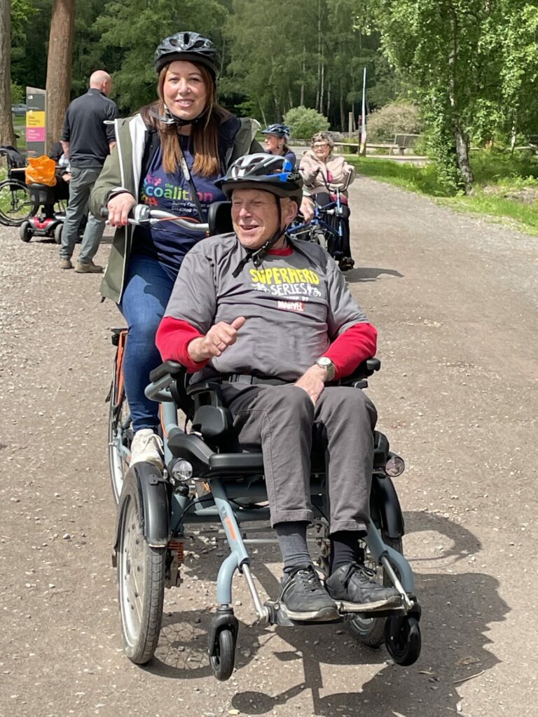 Coalition staff member Yasmin with Coalition member Jonathan on a wheelchair tandem bike.